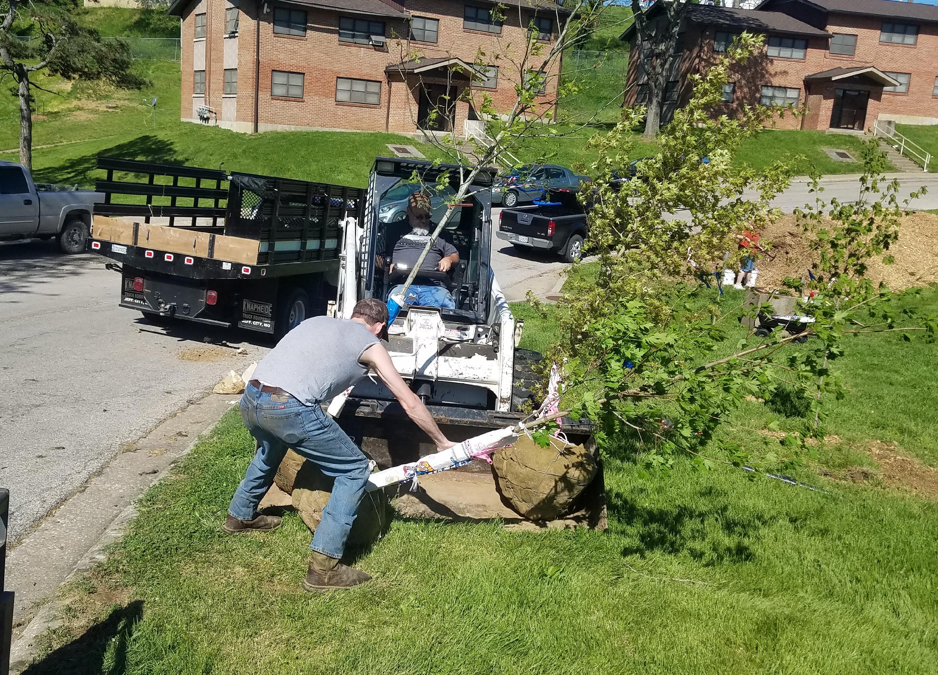 JCHA staff and volunteer remove a tree from a bobcat at JCHA tree planting May 1